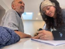 Two people at a table, one taking notes