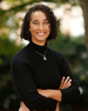 Woman standing outside with arms crossed smiling
