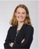 Woman stands with arms folded smiling